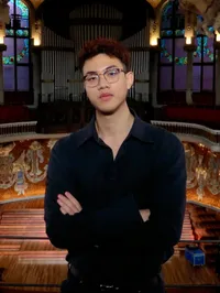 Xin Li, Teilnehmer des Young Talent Programms des cyberintelligence institute. Er steht vor einer beleuchteten Orgel einer Kirche.